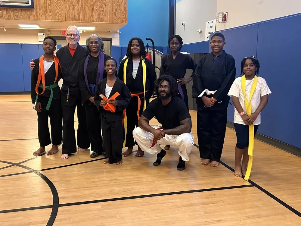 Young martial artists and adults gathered together